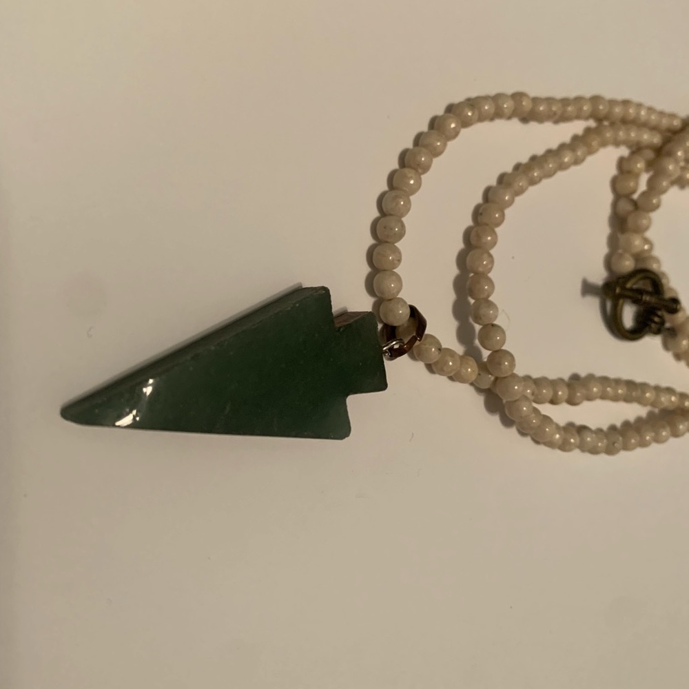 Bone-colored beaded necklace with green arrow